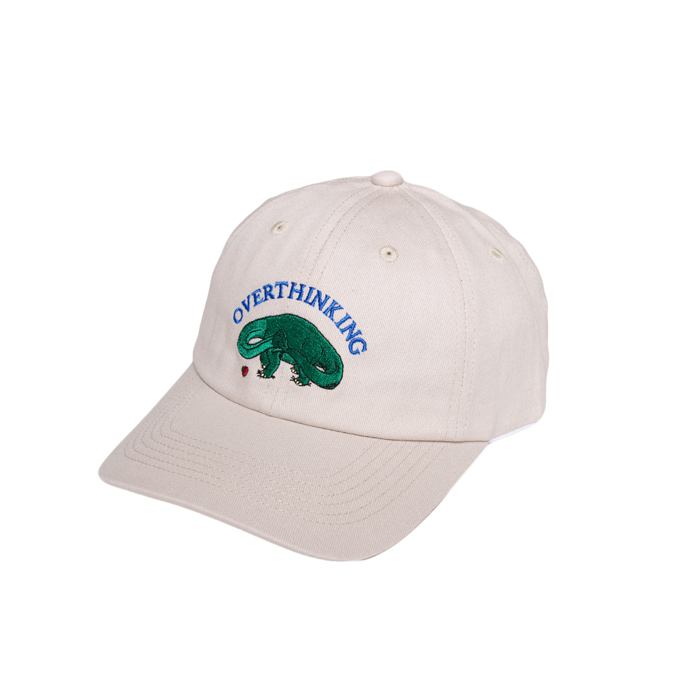 Beige cap with 'Overthinking' and a green dinosaur design on a white background