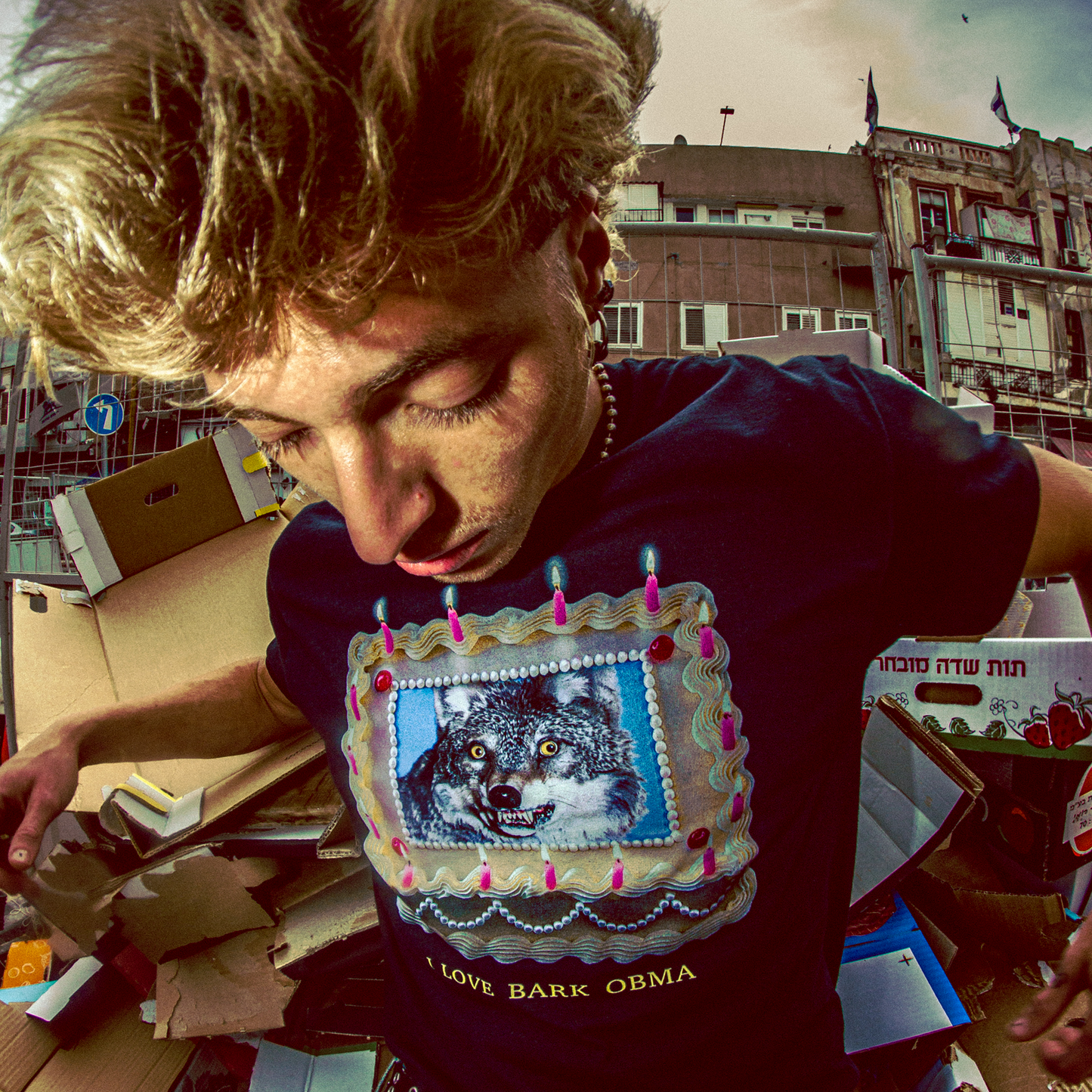 Person wearing a shirt with a wolf graphic and text, standing in an urban setting.