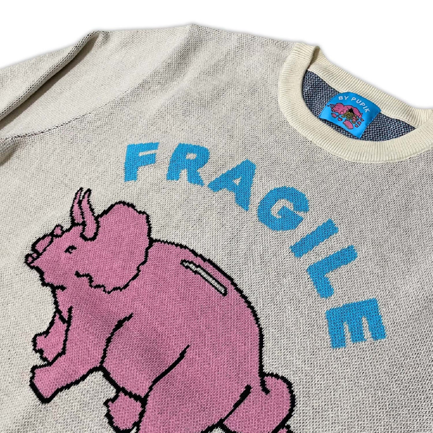 Close-up of the knitted texture and stitched graphic on the Fragile sweater