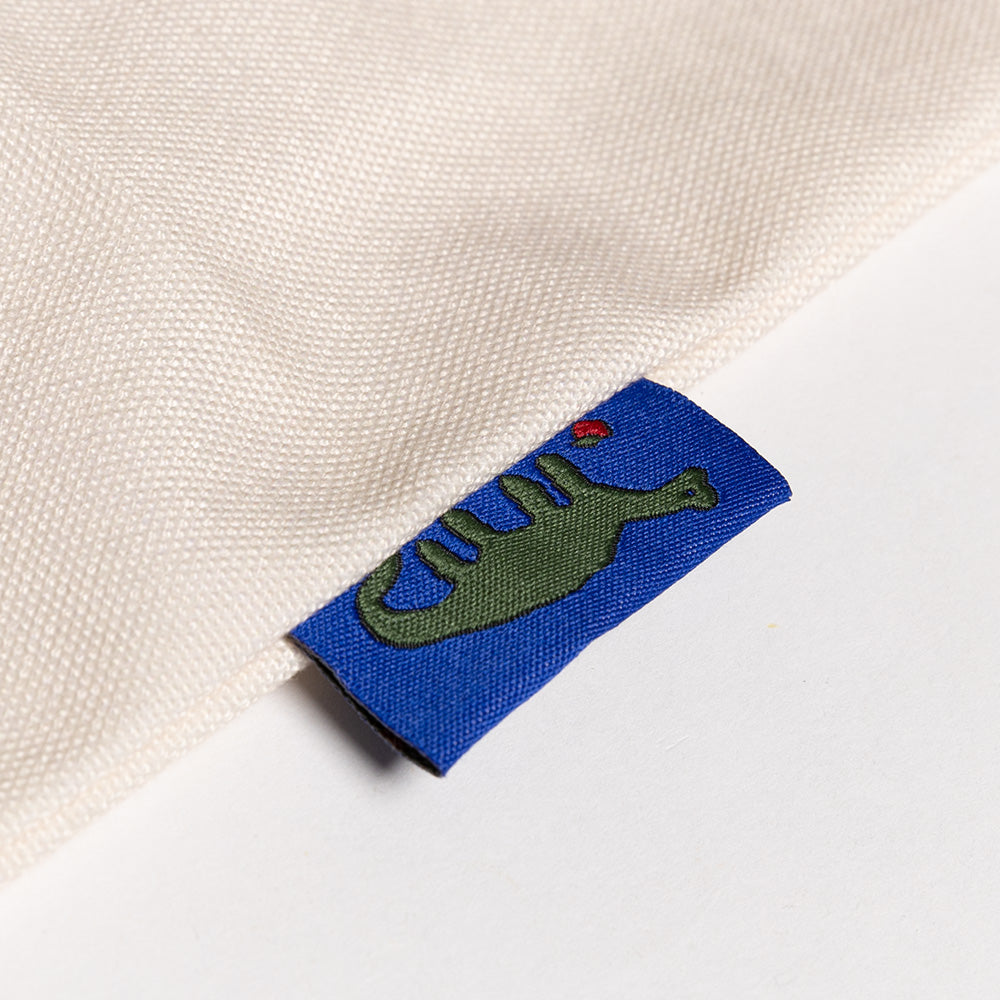 Embroidered label with a dinosaur design on a white fabric background