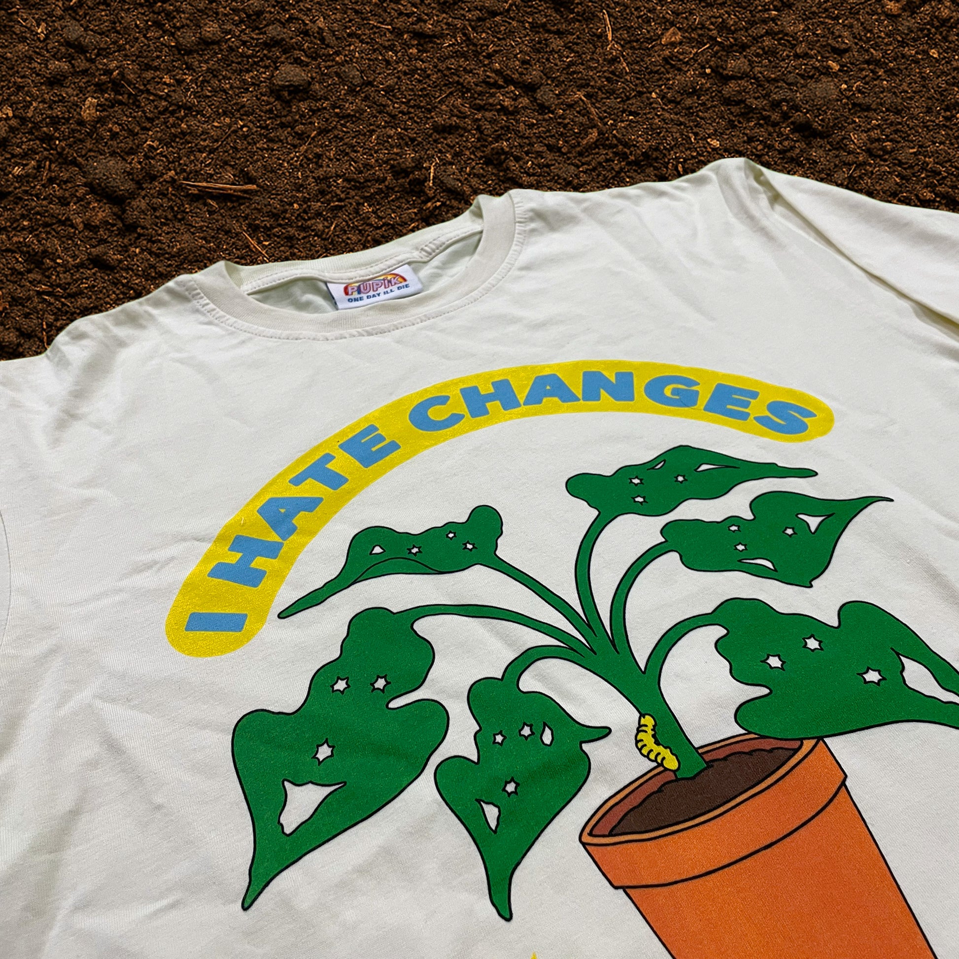 Close-up of Pupik I Hate Changes T-shirt print on soil background