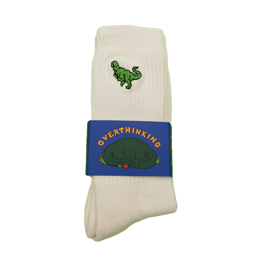 Cream socks with a small green Pupik embroidery and Overthinking packaging sleeve.