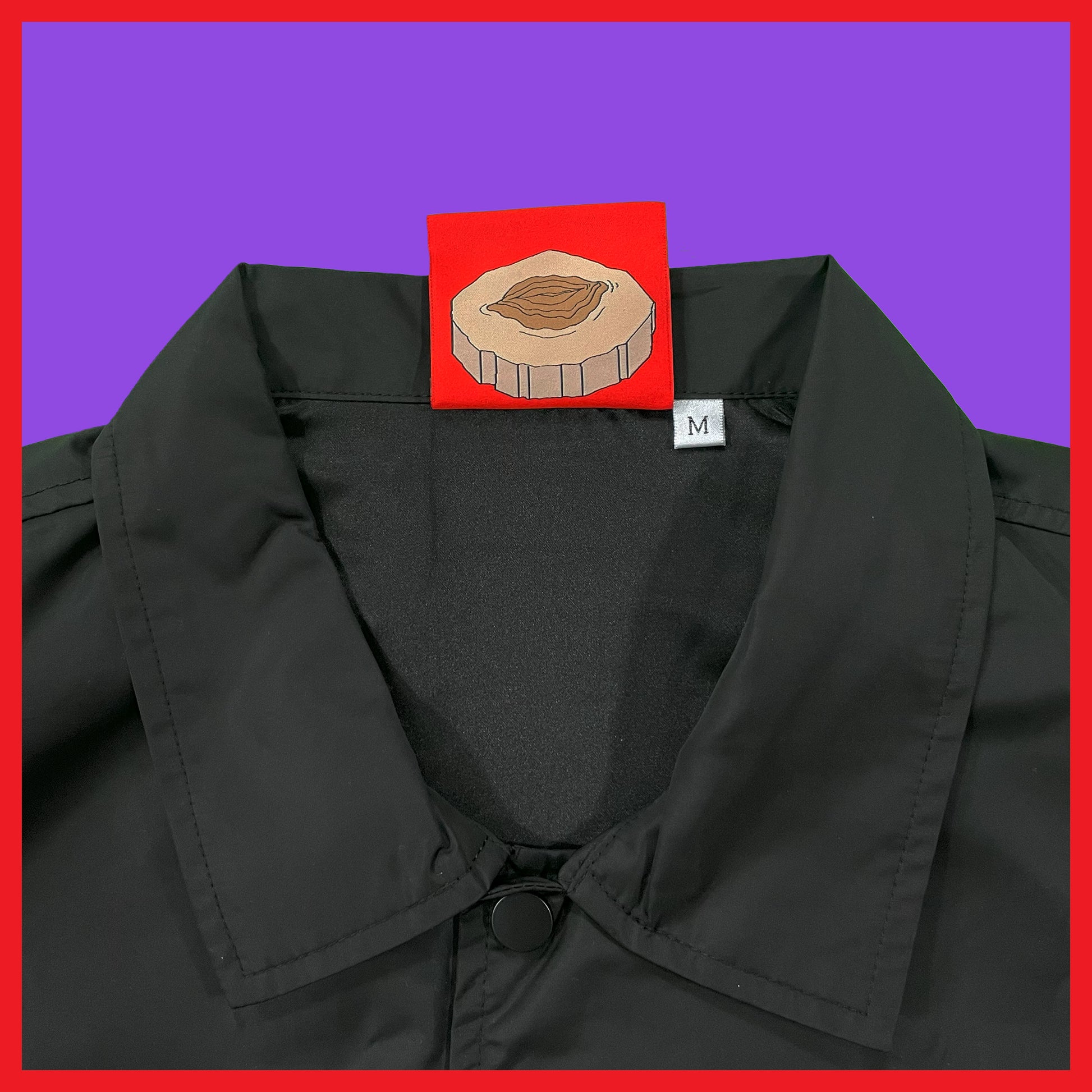 Close-up of Pupik The Fossil Hunter Windbreaker front logo and collar with red custom tag