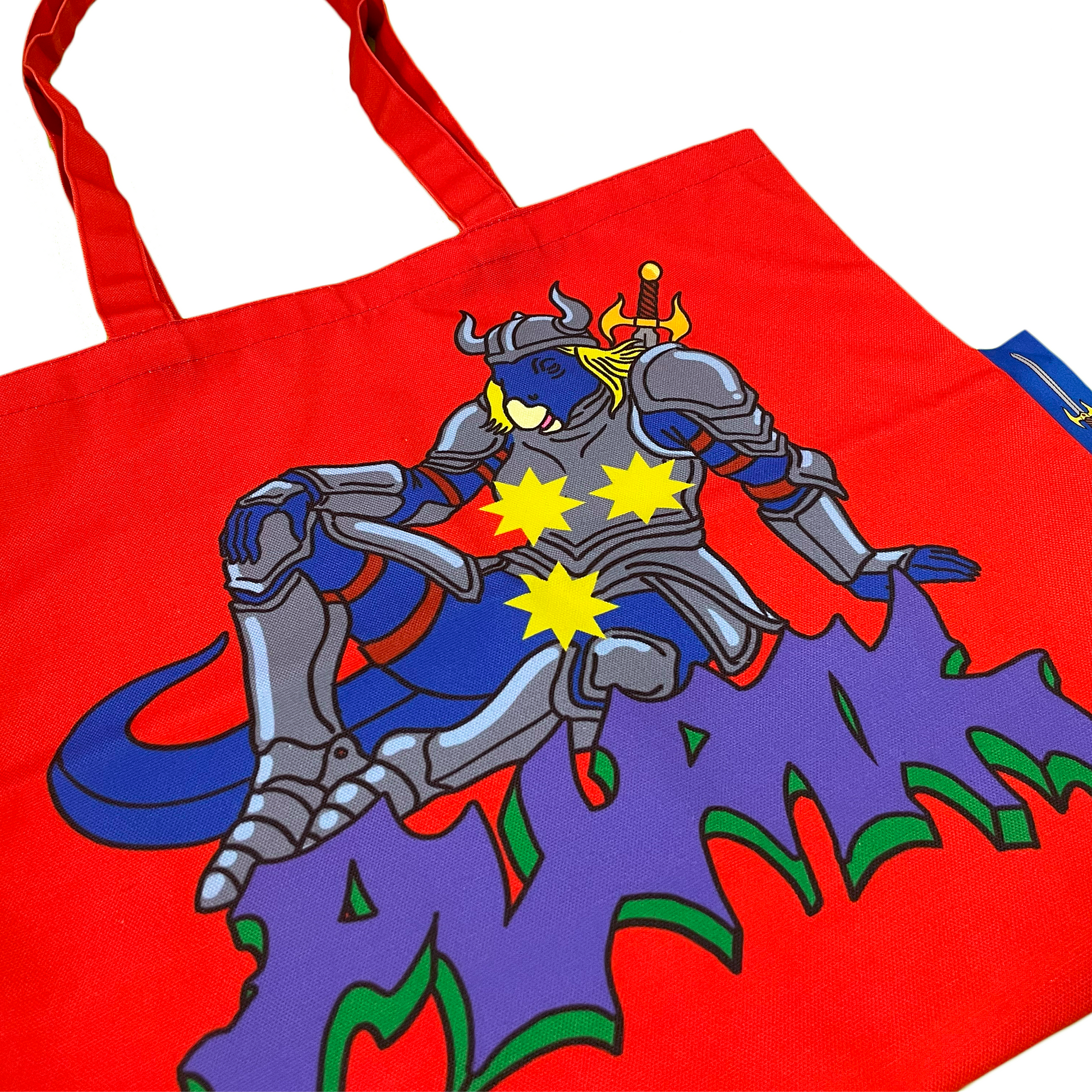 Pupik Red Tote Bag with blue knight design and side tag close up
