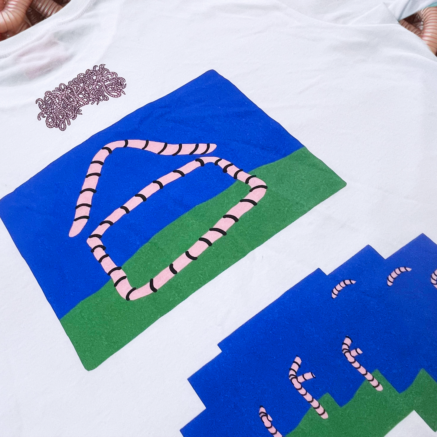 Pupik Worm House T-Shirt — white tee with front worm graphic and back worm-house illustrations.